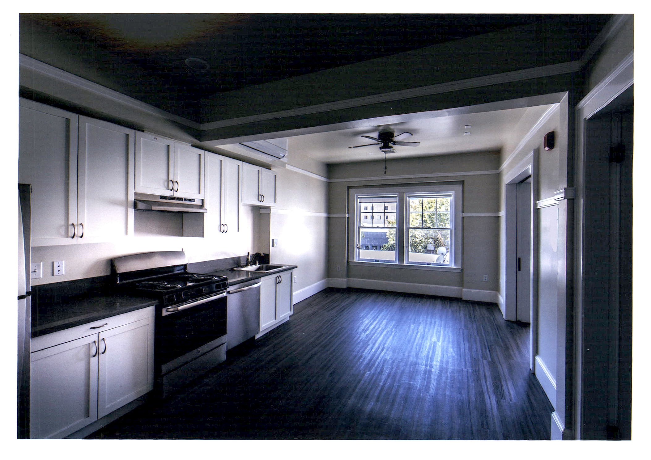 After: a view of the open living area with the new linear kitchen along the left wall.